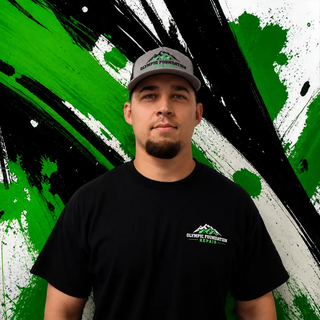 Portrait of a man in a gray cap and black shirt with Olympic Foundation Repair logo, against a green-black background.